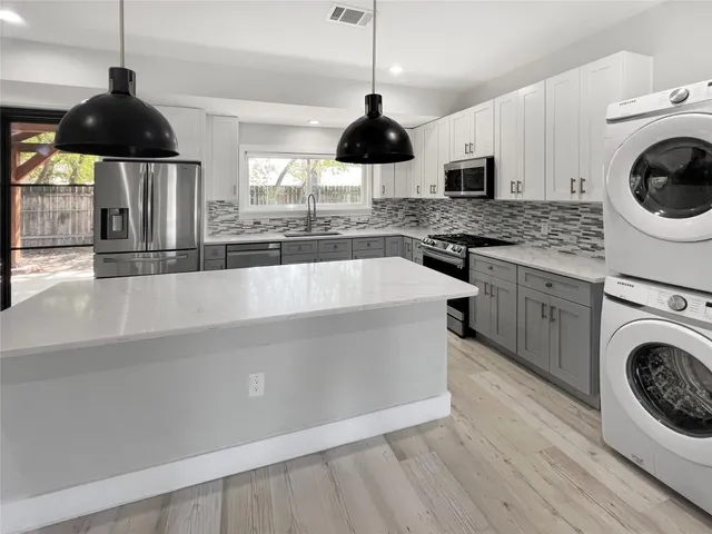 a kitchen with a sink a stove and stainless steel appliances