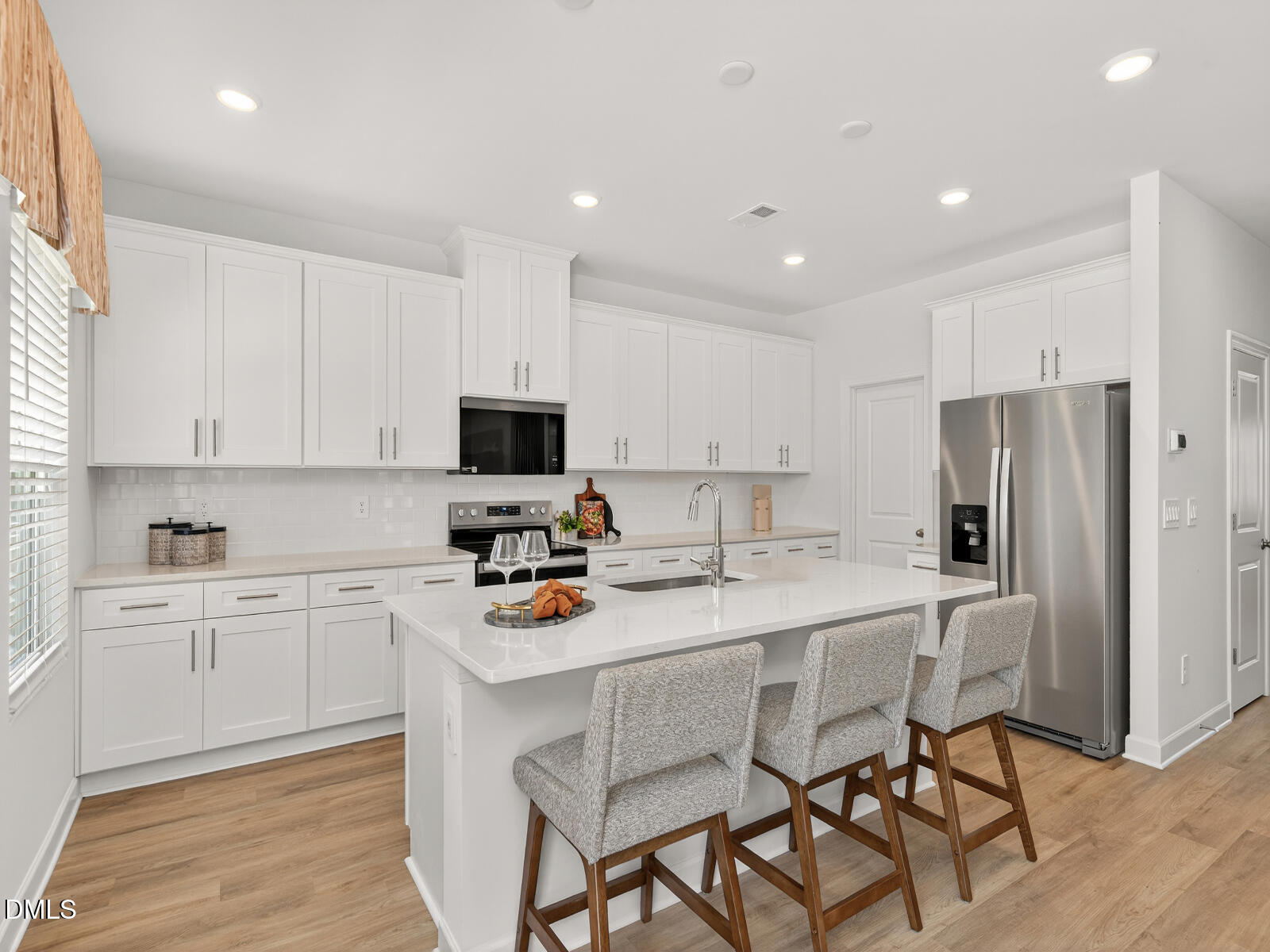 62 Thistle Patch Place Angier, NC 27501 - Photo 3 of 22 a kitchen with stainless steel appliances a stove a sink refrigerator and cabinets