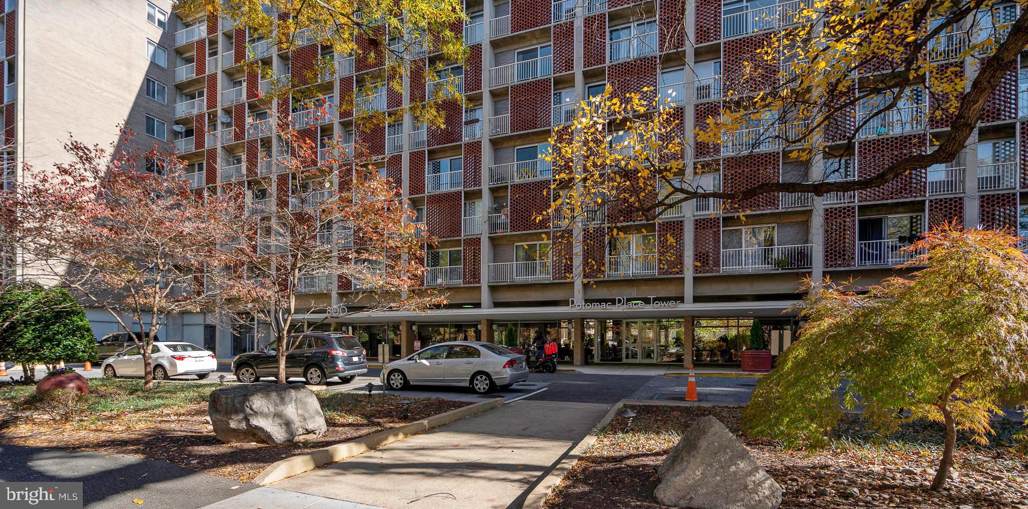 a front view of a building with lot of cars parked