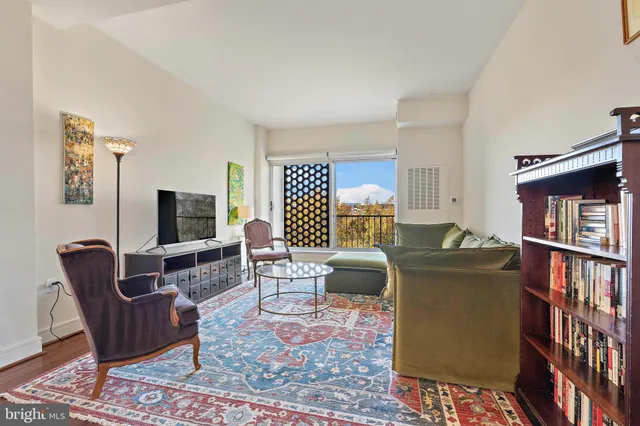 a living room with furniture a flat screen tv and a bookshelf