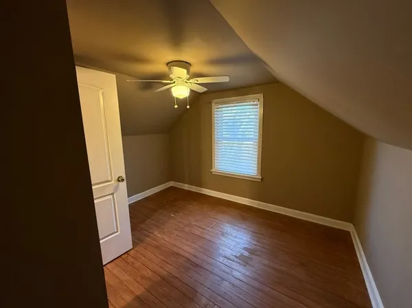 an empty room with wooden floor and window
