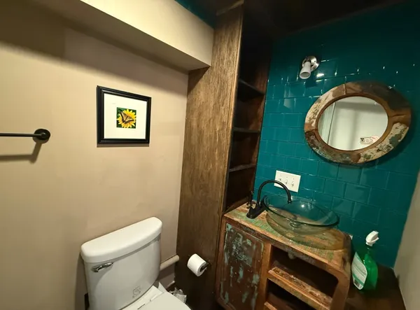 a bathroom with a toilet mirror and sink