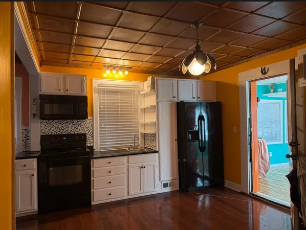 a view of a hallway with wooden floor and entryway