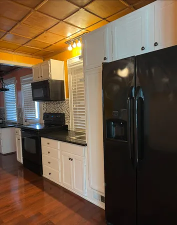 a kitchen with granite countertop a sink and cabinets