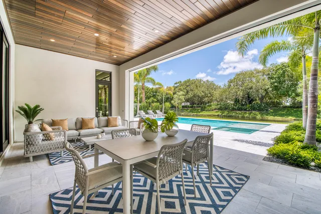 a living room with furniture floor to ceiling window and a table