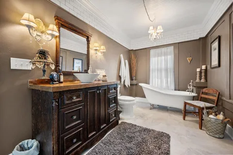 a living room with furniture a mirror and a chandelier