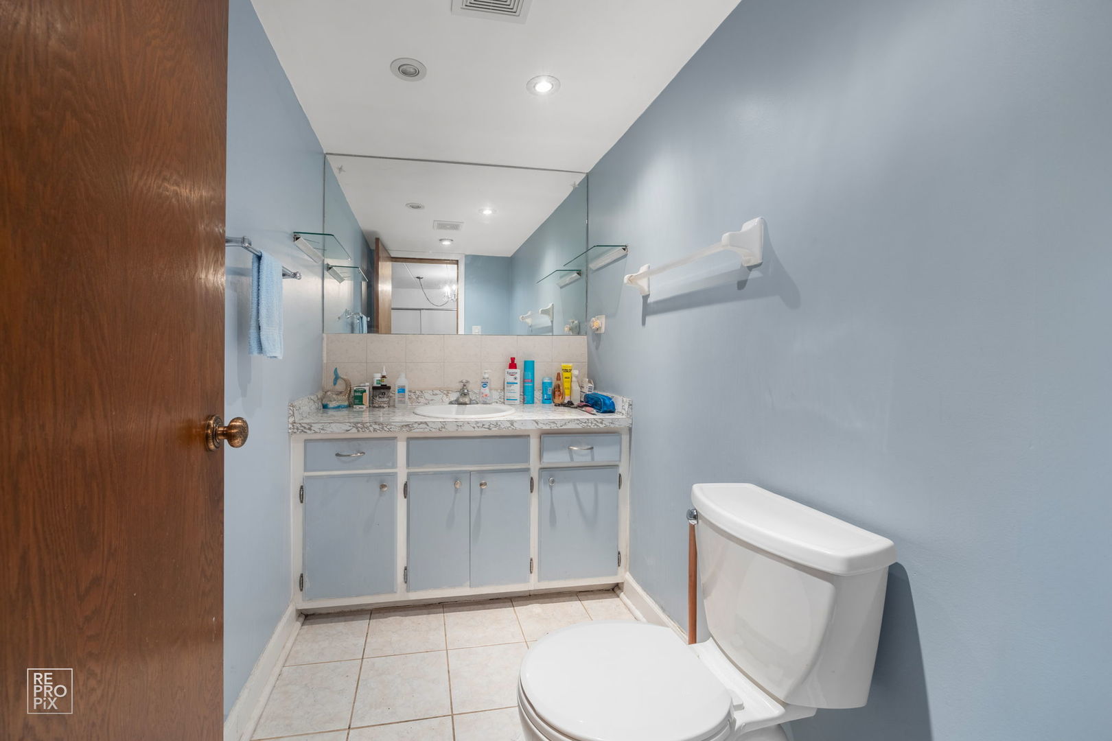8604 West 95th Street, Unit 102 Hickory Hills, IL 60457 - Photo 7 of 10 a bathroom with a toilet sink vanity and mirror