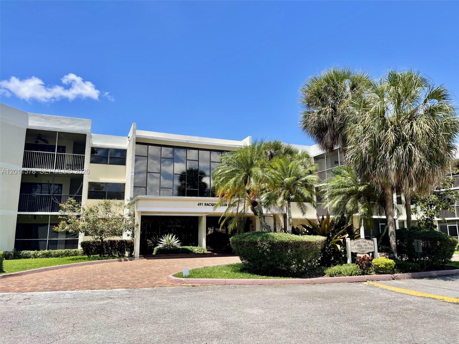 491 Racquet Club Road, Unit 303 Weston, FL 33326 - Photo 37 of 46 a front view of a house with a yard and garage