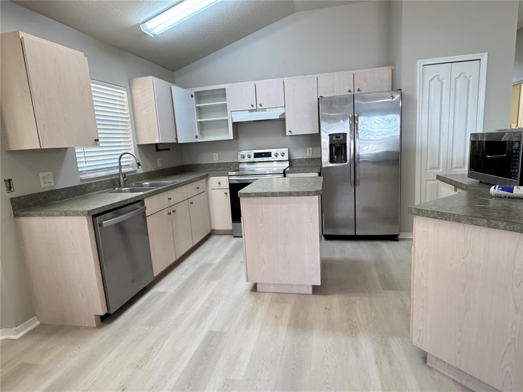 1414 Trail Boss Lane Brandon, FL 33511 - Photo 18 of 37 a kitchen with stainless steel appliances granite countertop a refrigerator sink and microwave