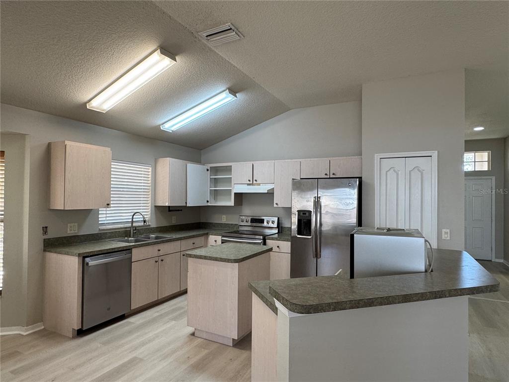 1414 Trail Boss Lane Brandon, FL 33511 - Photo 19 of 37 a kitchen with stainless steel appliances granite countertop a sink dishwasher stove top oven and refrigerator