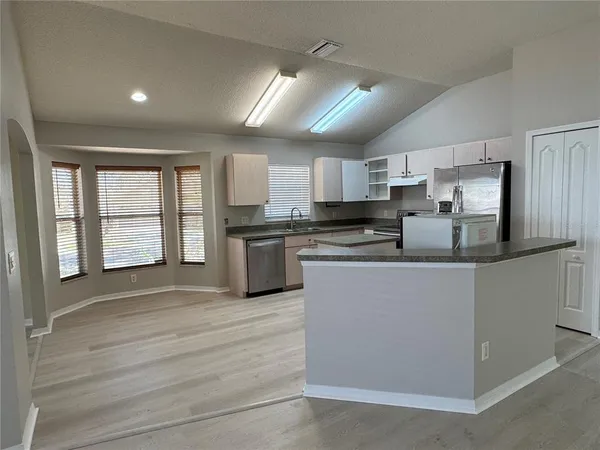 a kitchen with stainless steel appliances granite countertop a stove a sink and a refrigerator
