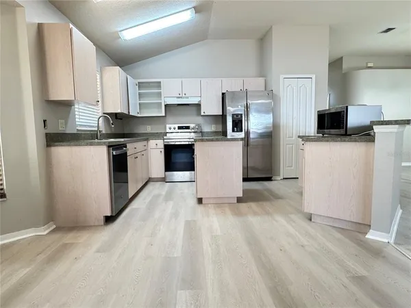 a kitchen with stainless steel appliances a refrigerator stove microwave and cabinets
