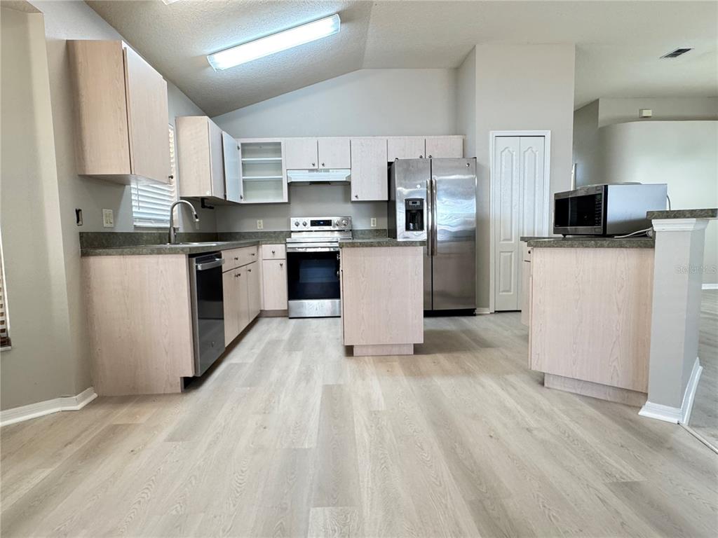 1414 Trail Boss Lane Brandon, FL 33511 - Photo 22 of 37 a kitchen with stainless steel appliances a refrigerator stove microwave and cabinets