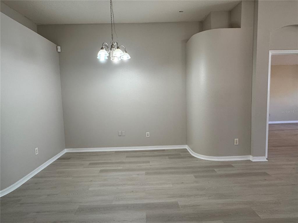 1414 Trail Boss Lane Brandon, FL 33511 - Photo 8 of 37 a view of an empty room with chandelier fan and kitchen view