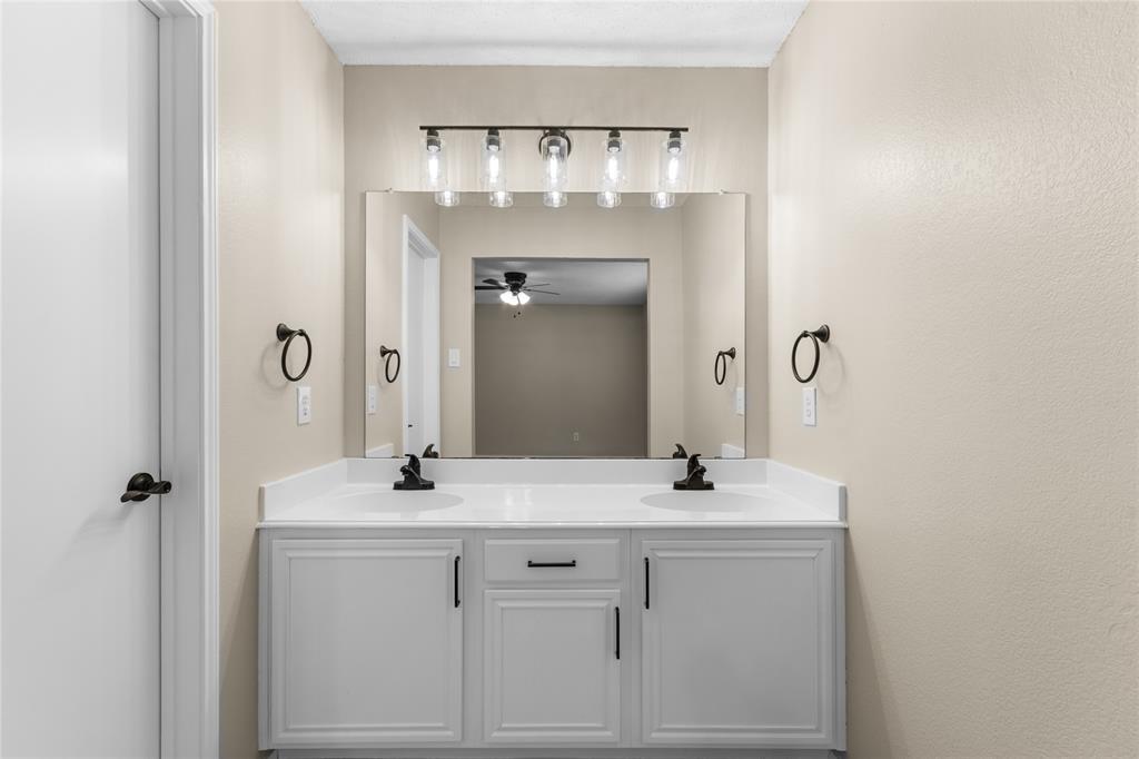 1035 North Ravinia Drive Dallas, TX 75211 - Photo 11 of 20 a bathroom with a sink vanity and a mirror