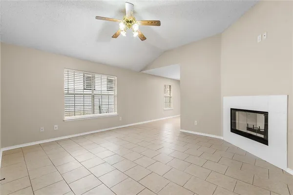 a view of an empty room with a fireplace and a window