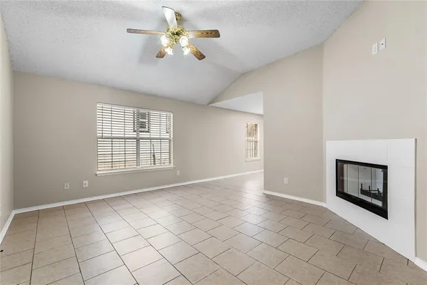 a view of an empty room with a fireplace and a window