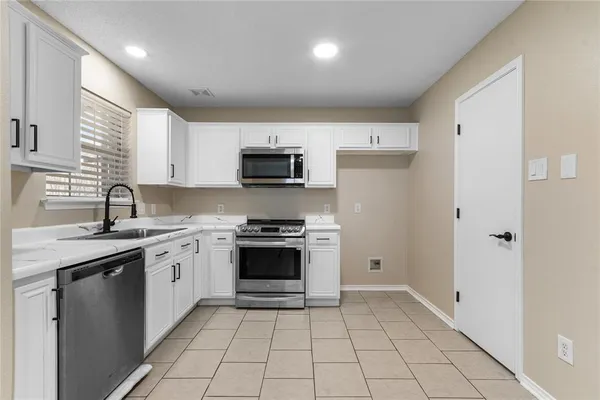 a kitchen with a sink a stove and cabinets