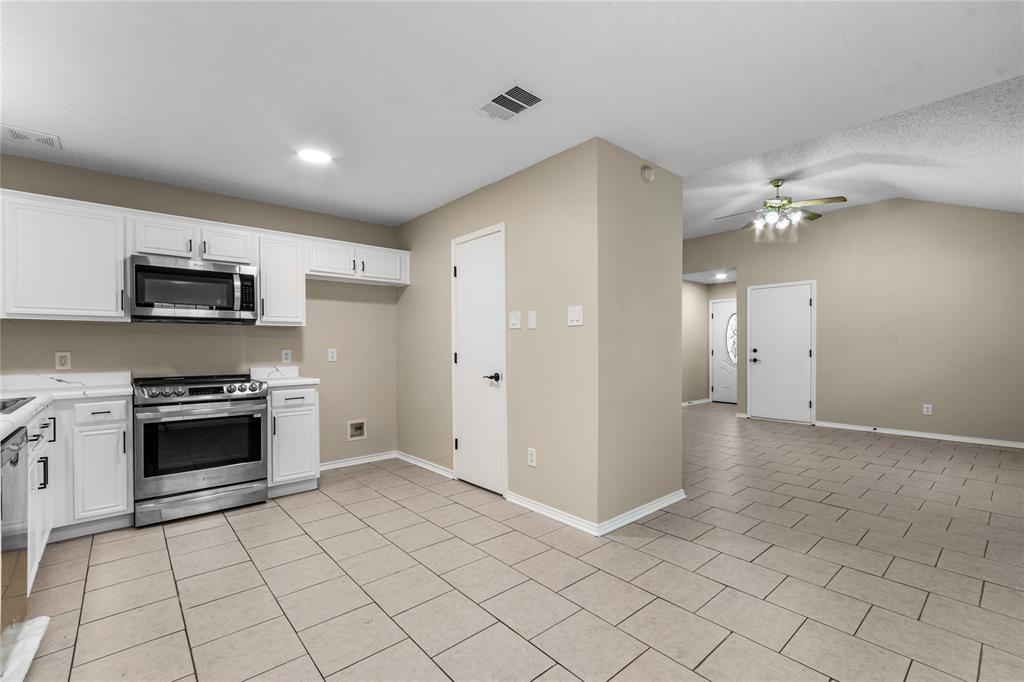 1035 North Ravinia Drive Dallas, TX 75211 - Photo 9 of 20 a view of a kitchen with microwave and stove top oven