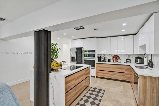 a kitchen with stainless steel appliances kitchen island granite countertop a sink and cabinets
