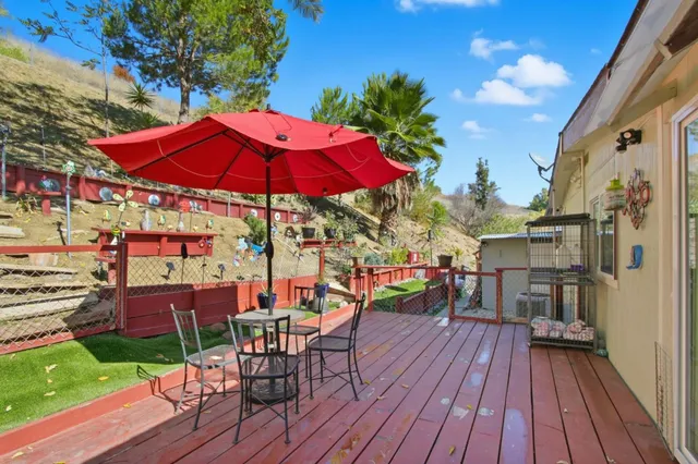 a view of a rooftop deck with chairs and umbrella