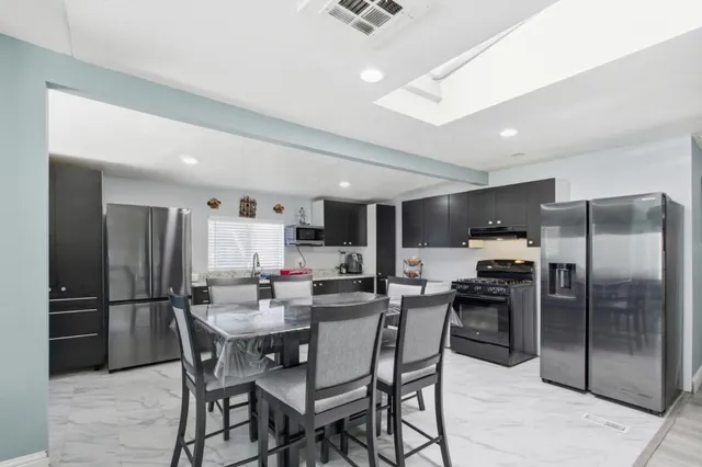 a view of a dining room and kitchen with a table chairs