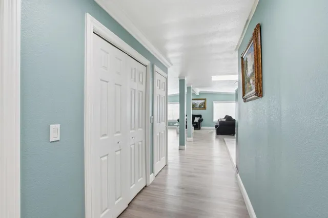 a hall way with wooden floor and furniture