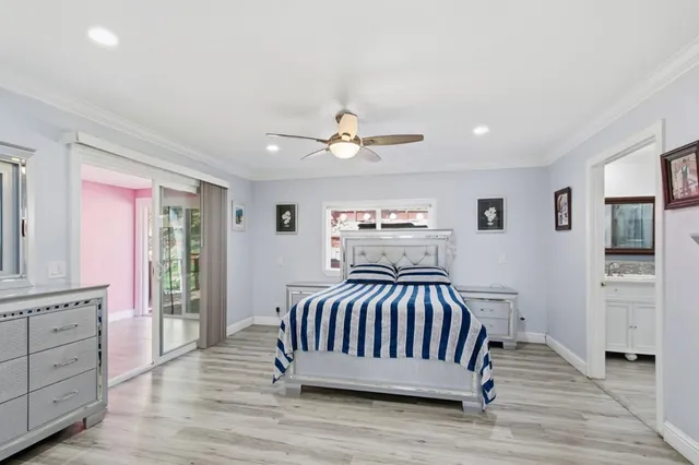 a bedroom with a large bed a chandelier and a window