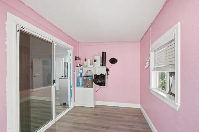 a view of a hallway with wooden floor and windows