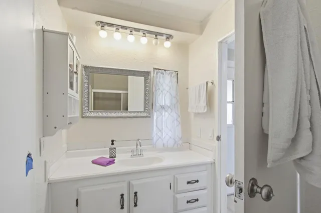 a bathroom with a granite countertop sink and a mirror