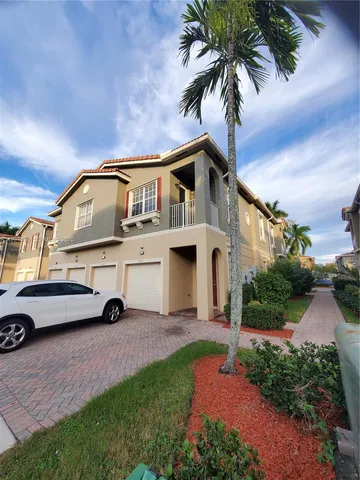 a view of a white house with a big yard and large trees