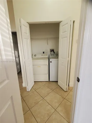 a utility room with cabinets washer and dryer