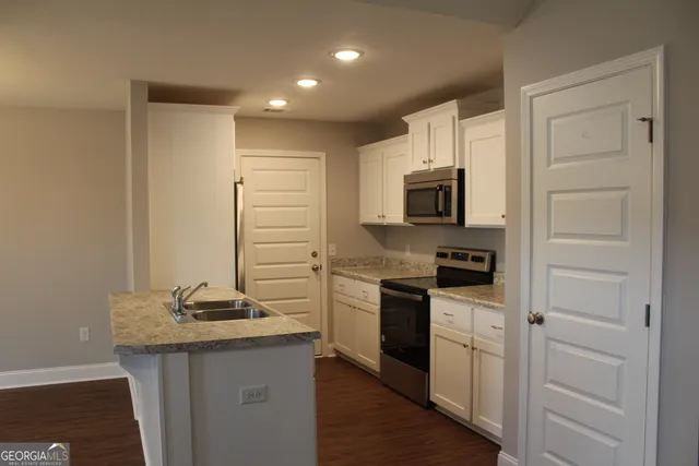 a kitchen with a sink stove and refrigerator