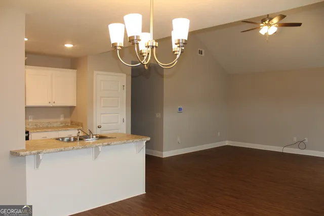 a room with wooden floor and white cabinet