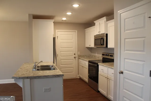 a kitchen with stainless steel appliances granite countertop a stove top oven a sink and dishwasher