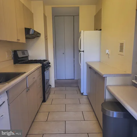 a kitchen with a stove a refrigerator and cabinets