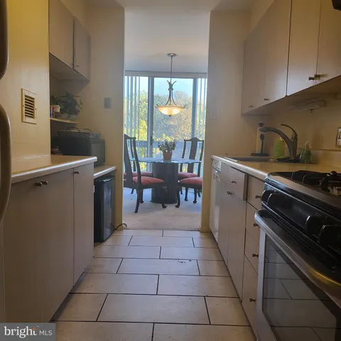 a kitchen with a stove a sink and a counter top space