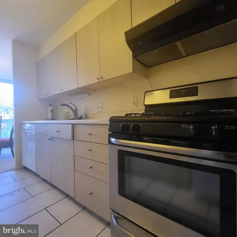 a kitchen with granite countertop white cabinets and black appliances