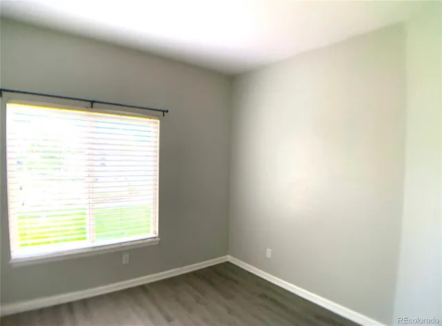 an empty room with wooden floor and a window