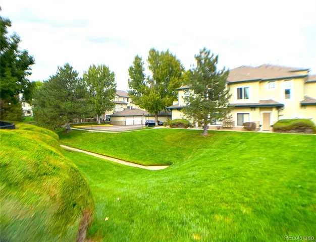 a view of a house with a big yard and large trees