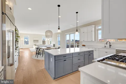 a kitchen with a sink stove and wooden floor