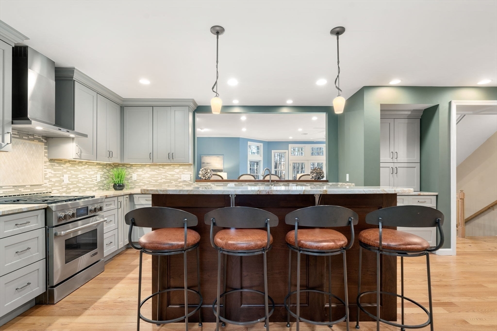 4 Plainview Road Wayland, MA 01778 - Photo 5 of 30 a kitchen with stainless steel appliances granite countertop a table and chairs in it