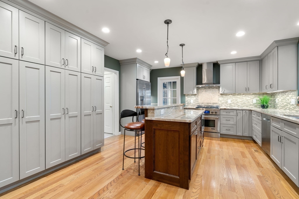 4 Plainview Road Wayland, MA 01778 - Photo 8 of 30 a kitchen with kitchen island granite countertop wooden floors and white cabinets