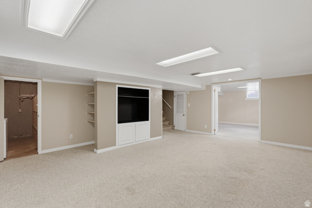 378 West 200 South Bountiful, UT 84010 - Photo 18 of 32 Expansive carpeted area featuring a built-in media cabinet with lower storage, recessed lighting, and wall shelving
