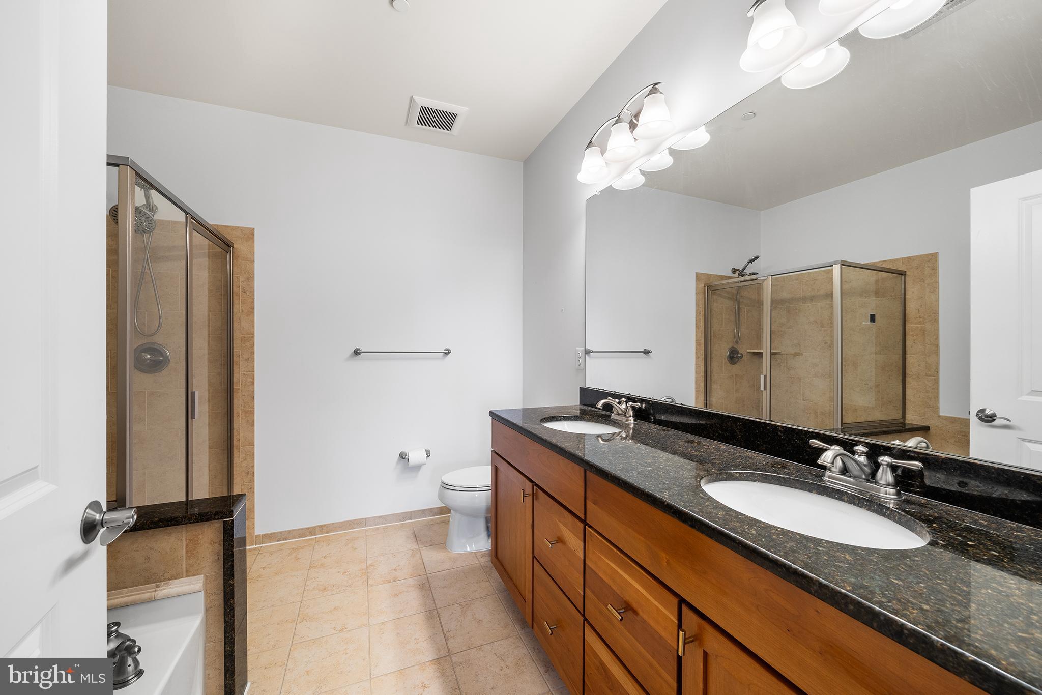 700 Commodore Court, Unit 2718 Philadelphia, PA 19146 - Photo 21 of 36 a bathroom with a granite countertop sink a mirror and a shower