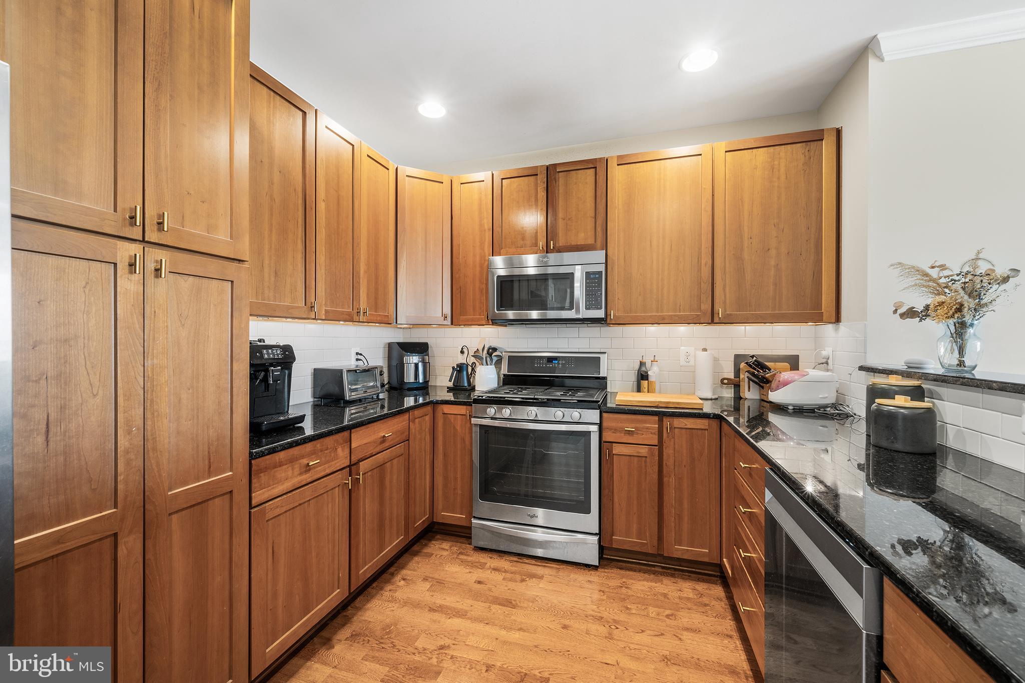 700 Commodore Court, Unit 2718 Philadelphia, PA 19146 - Photo 4 of 36 a kitchen with stainless steel appliances granite countertop a stove top oven a sink dishwasher and a refrigerator