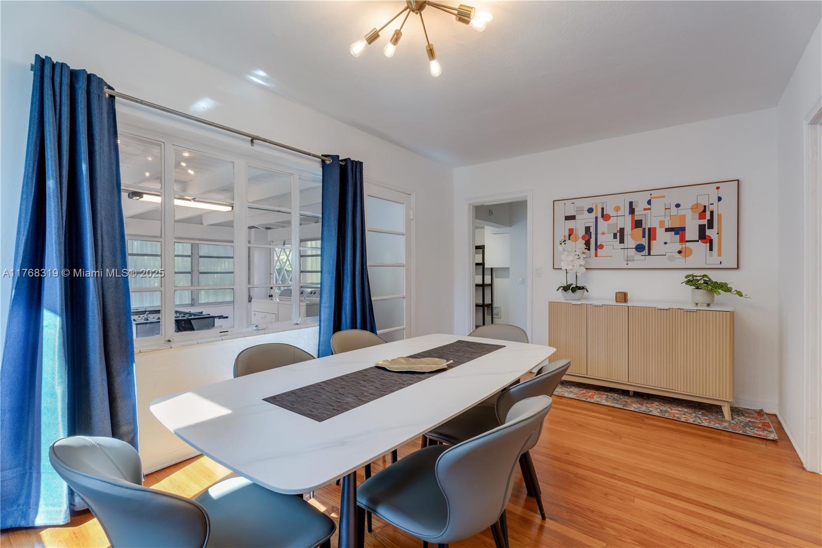 820 Southwest 26th Road Miami, FL 33129 - Photo 11 of 25 a view of a dining room with furniture a chandelier and wooden floor