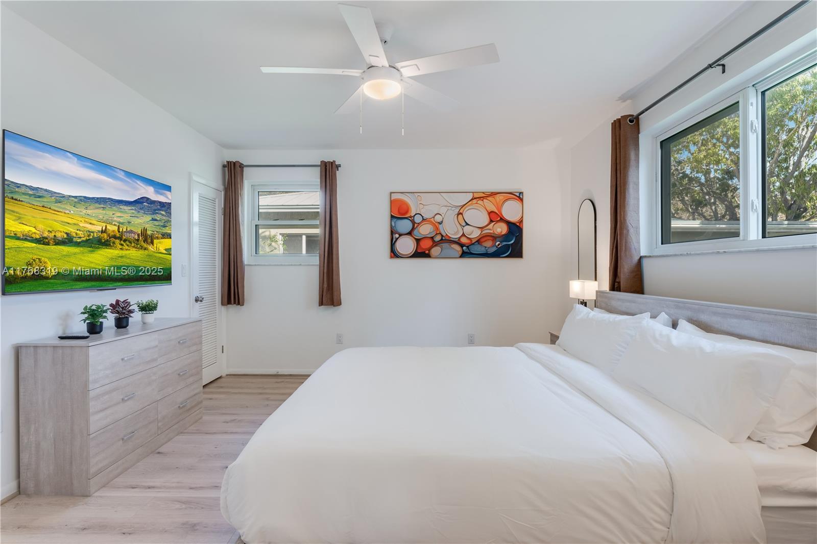 820 Southwest 26th Road Miami, FL 33129 - Photo 12 of 25 a bedroom with a flat screen tv on dresser and a window