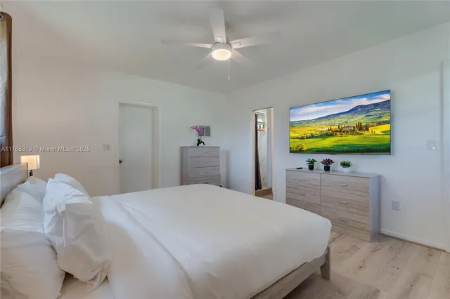 a bedroom with a bed and a flat screen tv