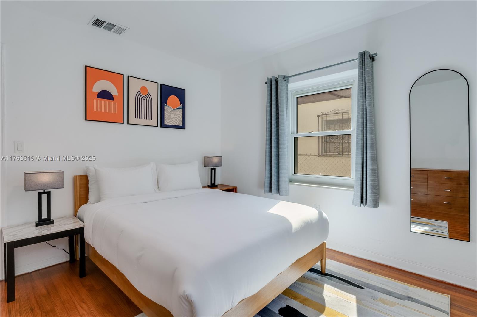 820 Southwest 26th Road Miami, FL 33129 - Photo 16 of 25 a bedroom with a bed and wooden floor